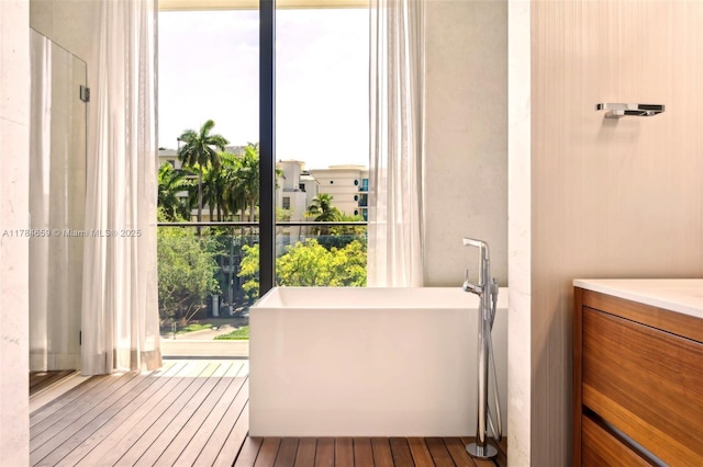 3581 E Glencoe St Unit 309, Miami, FL 33133 - full bathroom featuring a soaking tub and wood-type flooring