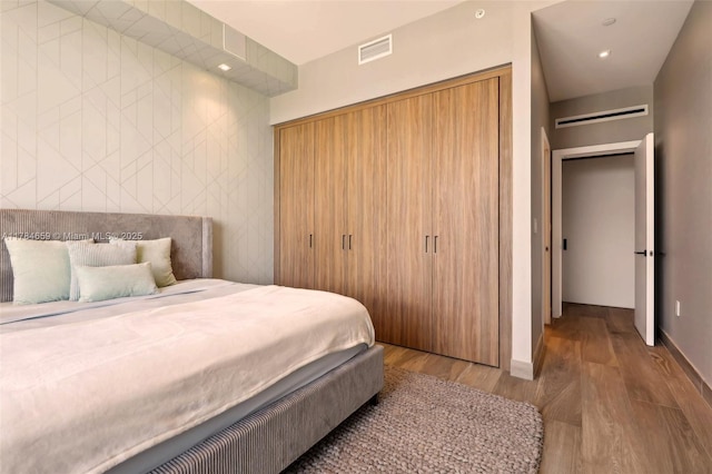 3581 E Glencoe St Unit 309, Miami, FL 33133 - bedroom featuring baseboards, visible vents, and wood finished floors