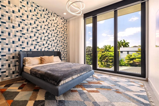 3581 E Glencoe St Unit 309, Miami, FL 33133 - bedroom featuring an inviting chandelier, access to outside, and baseboards