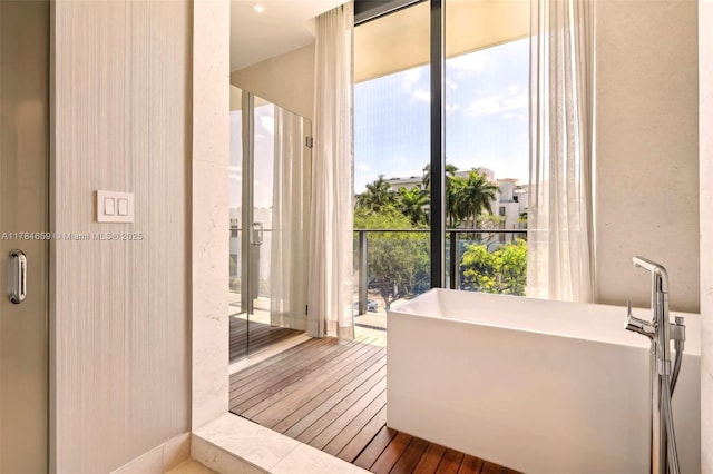 3581 E Glencoe St Unit 309, Miami, FL 33133 - bathroom with a freestanding bath and wood finished floors