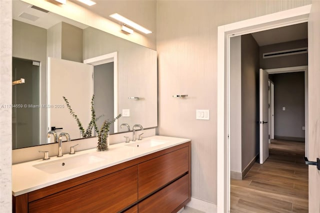 3581 E Glencoe St Unit 309, Miami, FL 33133 - full bathroom featuring baseboards, double vanity, a sink, and wood finished floors