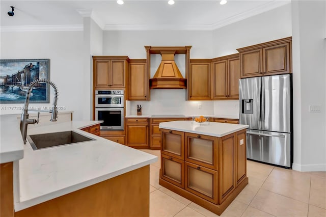 kitchen with stainless steel appliances, a sink, a kitchen island, brown cabinetry, and custom exhaust hood