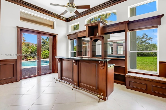 interior space featuring wainscoting, a ceiling fan, ornamental molding, and french doors