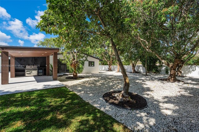 15201 SW 87th Ct, Palmetto Bay, FL 33157 - view of yard with a fenced backyard, a patio, and an outdoor kitchen