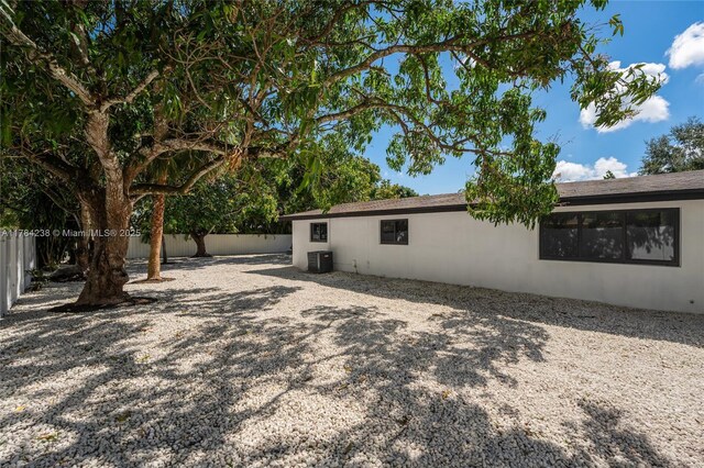 15201 SW 87th Ct, Palmetto Bay, FL 33157 - view of property exterior featuring central AC unit, a fenced backyard, and stucco siding