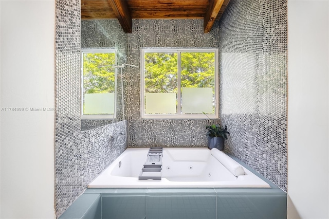 full bath featuring a jetted tub and beam ceiling