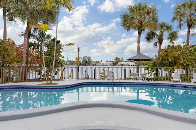 community pool with a patio area and fence