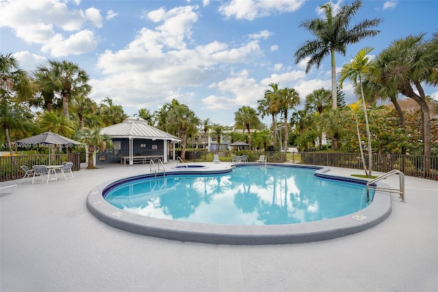 community pool with a gazebo, a patio, and fence