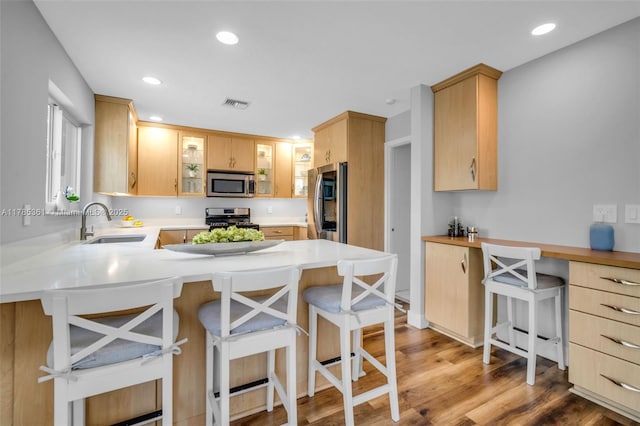 13473 NW 5th Ct, Plantation, FL 33325 - kitchen with light brown cabinets, a peninsula, glass insert cabinets, appliances with stainless steel finishes, and a sink