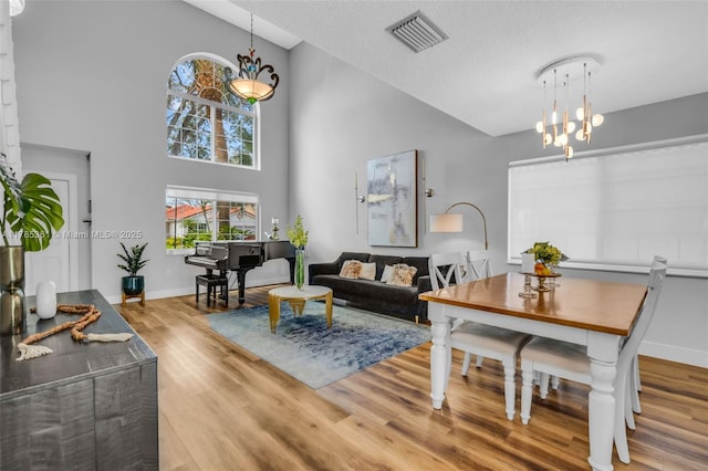 13473 NW 5th Ct, Plantation, FL 33325 - living room with high vaulted ceiling, visible vents, wood finished floors, baseboards, and a notable chandelier