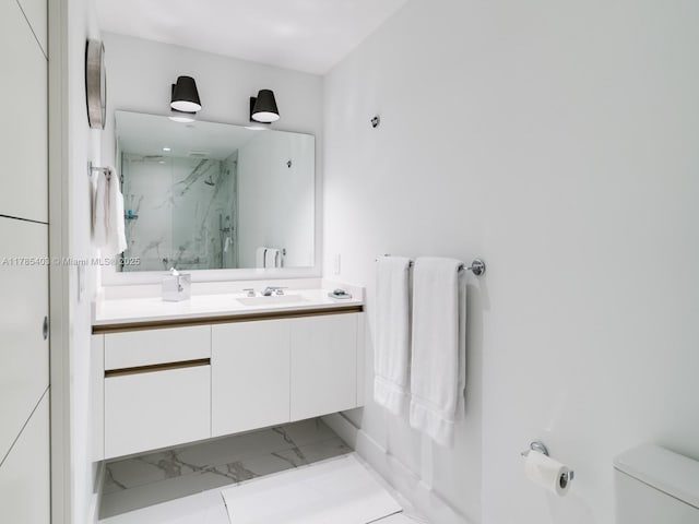 bathroom with toilet, marble finish floor, vanity, and a marble finish shower