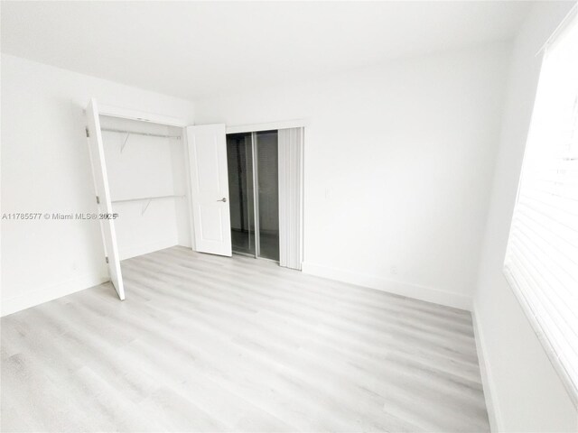 60 Burgundy B 60, Delray Beach, FL 33484 - unfurnished bedroom with a closet, baseboards, and light wood finished floors