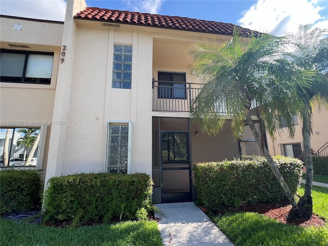 exterior space with a tile roof and stucco siding