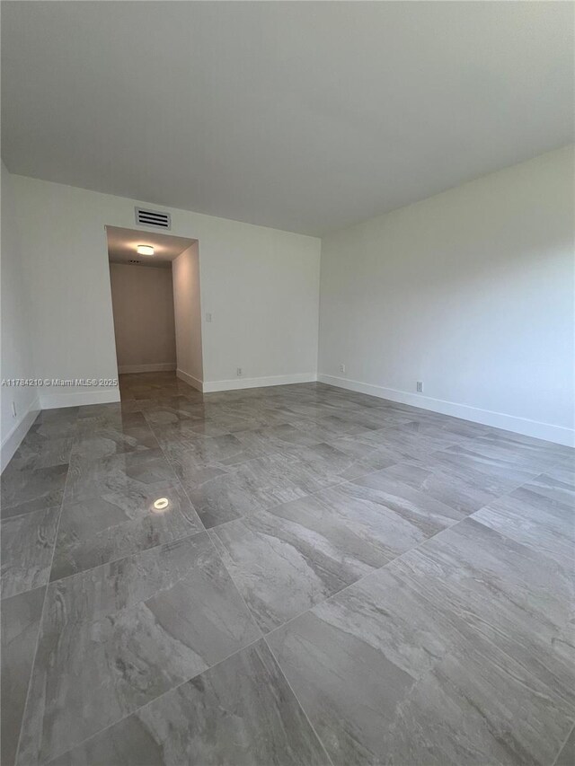 spare room featuring visible vents, baseboards, and marble finish floor
