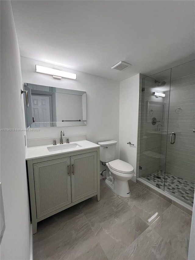 bathroom featuring visible vents, toilet, vanity, marble finish floor, and a stall shower