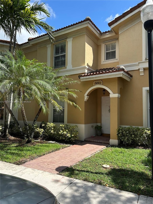 mediterranean / spanish-style home featuring stucco siding and a tile roof