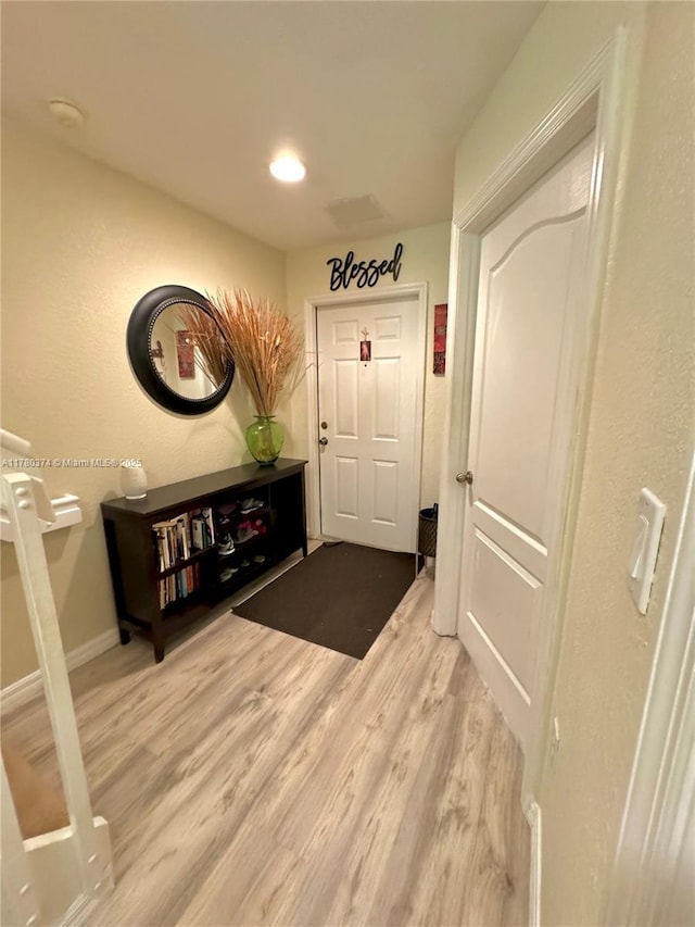 foyer entrance with light wood-style flooring, baseboards, and recessed lighting