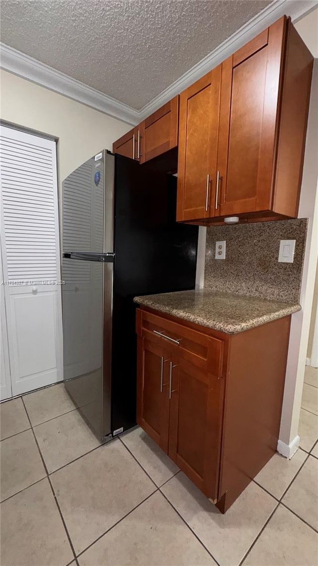 10795 SW 108th Ave Unit 103, Miami, FL 33176 - kitchen featuring tasteful backsplash, light tile patterned floors, a textured ceiling, crown molding, and brown cabinets