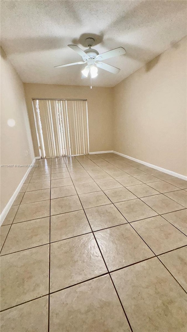 10795 SW 108th Ave Unit 103, Miami, FL 33176 - spare room featuring a textured ceiling, light tile patterned floors, and baseboards