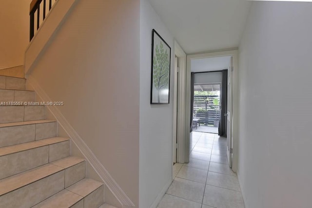 staircase featuring baseboards and tile patterned flooring