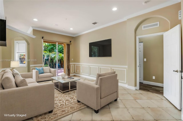 living room with arched walkways, ornamental molding, wainscoting, recessed lighting, and light tile patterned floors