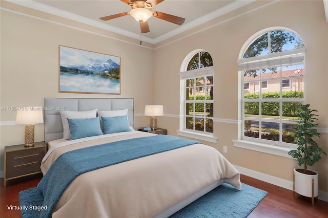 bedroom featuring baseboards, crown molding, wood finished floors, and a ceiling fan