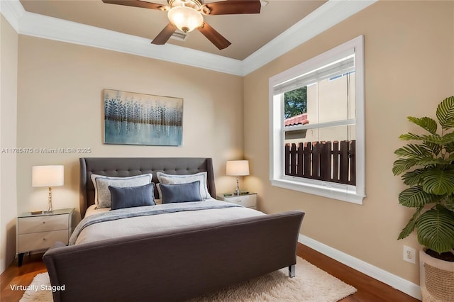 bedroom featuring baseboards, wood finished floors, ornamental molding, and a ceiling fan