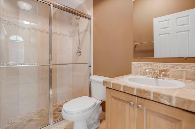 full bathroom featuring toilet, a shower stall, and vanity