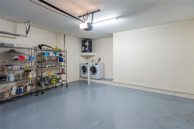 garage featuring washing machine and dryer, a garage door opener, and water heater