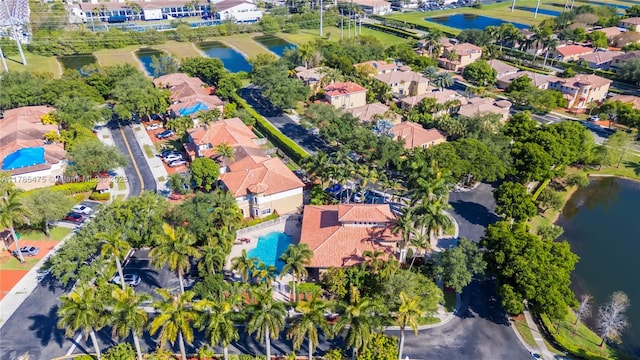 view of property location with a nearby body of water, nearby suburban area, and a pool