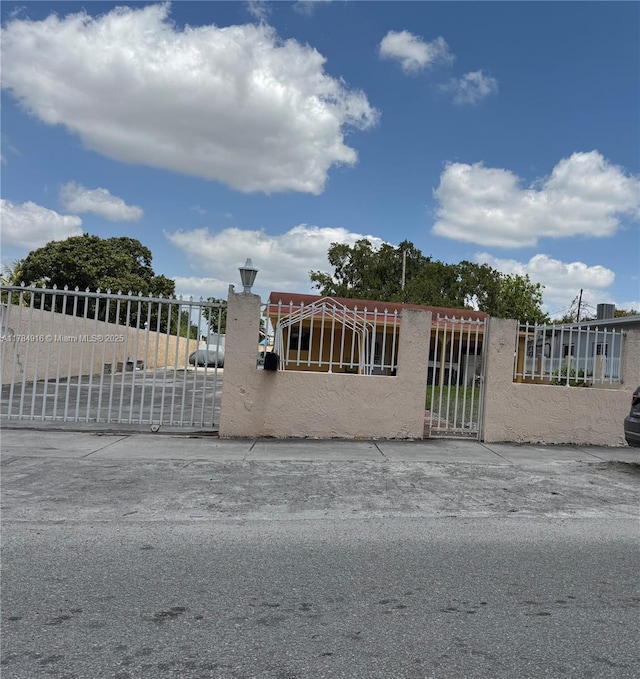 view of gate with a fenced front yard