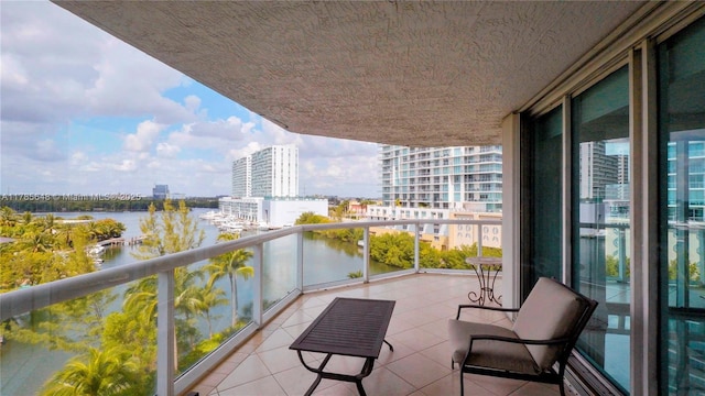 balcony with a water view and a view of city