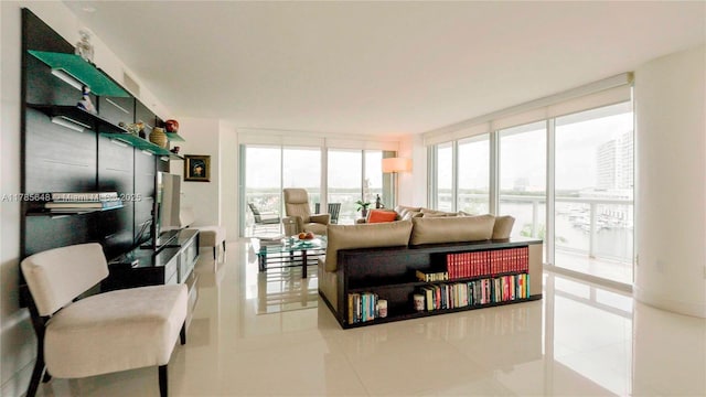 living room with a wall of windows and tile patterned flooring