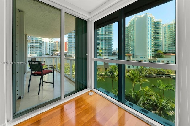 16500 Collins Ave Unit 656, Sunny Isles Beach, FL 33160 - unfurnished sunroom with a view of city, a water view, wood finished floors, and expansive windows