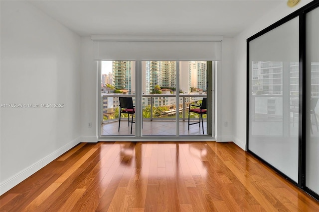 16500 Collins Ave Unit 656, Sunny Isles Beach, FL 33160 - spare room featuring wood finished floors, baseboards, and a city view
