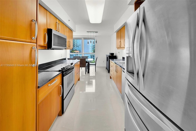 16500 Collins Ave Unit 656, Sunny Isles Beach, FL 33160 - kitchen featuring appliances with stainless steel finishes, dark countertops, brown cabinetry, decorative light fixtures, and a sink
