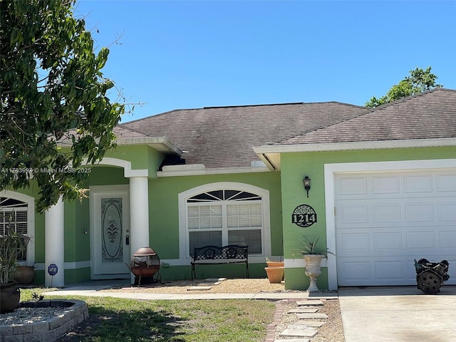 1214 SW Patricia Ave, Port St Lucie, FL 34953 - view of front of house featuring concrete driveway, stucco siding, a garage, and roof with shingles
