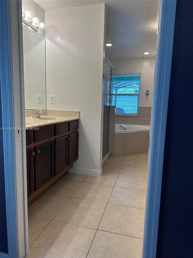 1214 SW Patricia Ave, Port St Lucie, FL 34953 - full bathroom with tile patterned floors, vanity, a garden tub, a shower stall, and baseboards