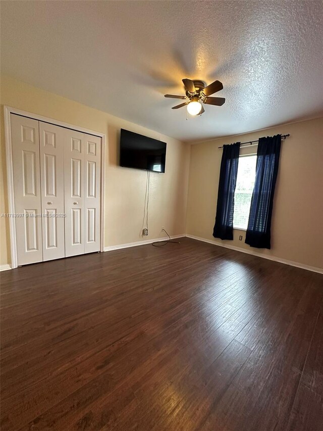 1214 SW Patricia Ave, Port St Lucie, FL 34953 - unfurnished bedroom featuring dark wood-style floors, baseboards, ceiling fan, and a textured ceiling