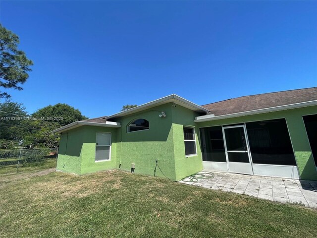1214 SW Patricia Ave, Port St Lucie, FL 34953 - back of house with stucco siding, a patio, and a sunroom