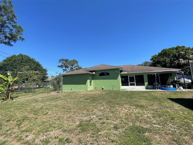 1214 SW Patricia Ave, Port St Lucie, FL 34953 - back of property with fence, a sunroom, a lawn, and stucco siding