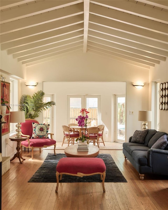 living area with wood-type flooring and lofted ceiling with beams