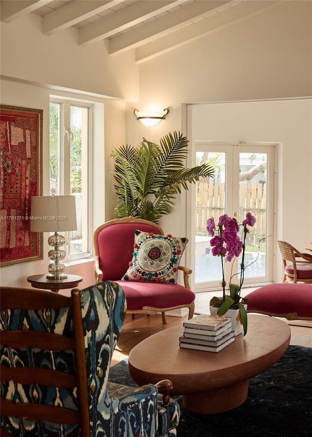 living area featuring a wealth of natural light, french doors, and lofted ceiling with beams