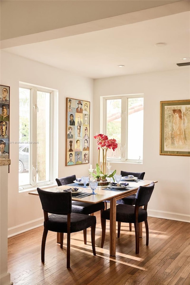 dining space with baseboards and wood finished floors