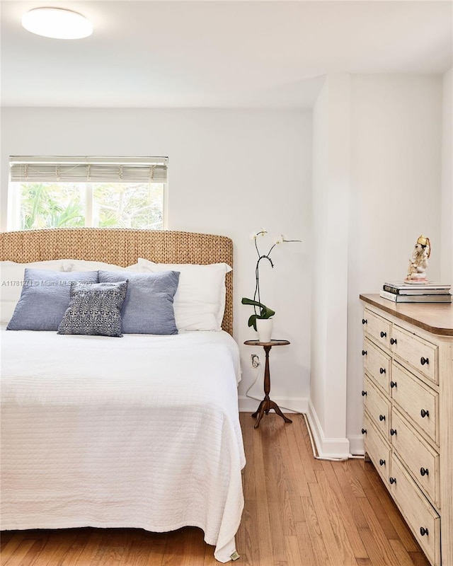 bedroom with light wood finished floors and baseboards
