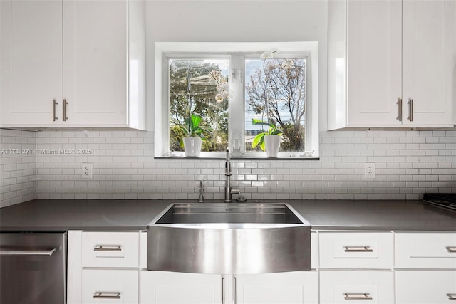 kitchen with white cabinetry, a sink, and backsplash
