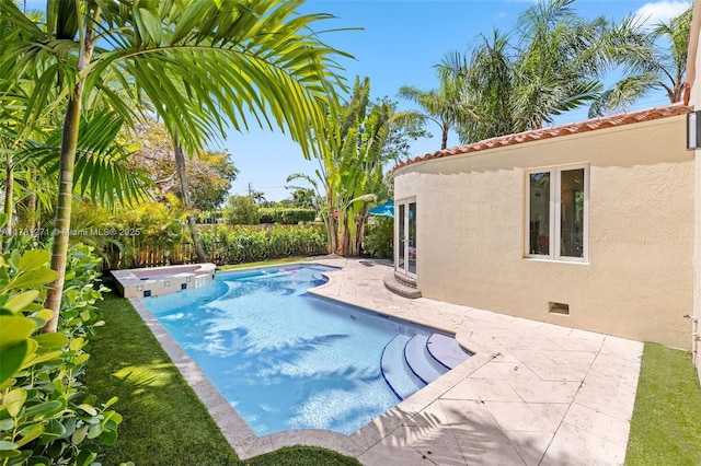 view of pool with a patio, fence, a fenced in pool, and an in ground hot tub