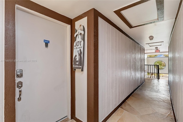 9660 S Belfort Cir Unit 207, Tamarac, FL 33321 - hallway featuring stone tile flooring, attic access, and an upstairs landing
