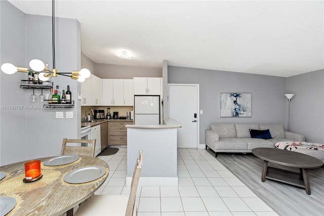 9660 S Belfort Cir Unit 207, Tamarac, FL 33321 - kitchen featuring freestanding refrigerator, open floor plan, white cabinets, a sink, and light tile patterned floors
