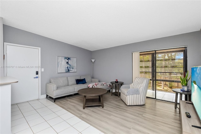 9660 S Belfort Cir Unit 207, Tamarac, FL 33321 - living area featuring light wood finished floors, vaulted ceiling, and baseboards
